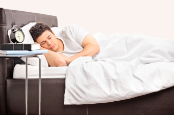 Young man sleeping on a comfortable bed
